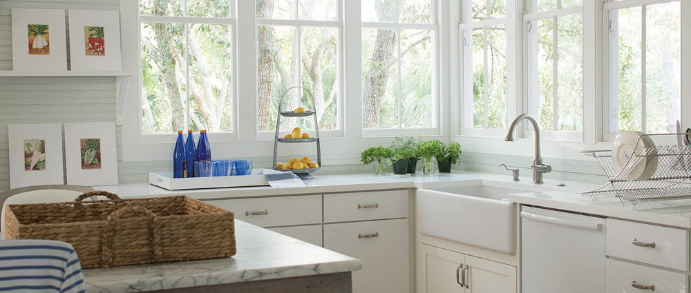 kitchen with big windows, white cabinetry and an island with whicker tray on top